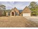 Beautiful brick home featuring an arched entrance, large windows, and well-maintained landscaping at 2915 Pruitt Rd, Cumming, GA 30041