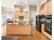 Bright kitchen featuring an island, black appliances, and hardwood floors at 2915 Pruitt Rd, Cumming, GA 30041