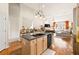 Kitchen island with granite countertops and wood floors leading into living room with fireplace at 2915 Pruitt Rd, Cumming, GA 30041