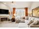 Cozy living room with fireplace, large windows with bright orange drapes, and comfortable seating at 2915 Pruitt Rd, Cumming, GA 30041