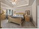 Main bedroom featuring tray ceilings, neutral colors, and en suite bathroom at 2915 Pruitt Rd, Cumming, GA 30041