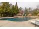 In-ground pool with waterfall feature and stone surround, perfect for enjoying outdoor living at 2915 Pruitt Rd, Cumming, GA 30041