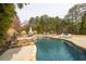 Backyard pool featuring waterfall, stone border, and lounge chairs with ample patio space at 2915 Pruitt Rd, Cumming, GA 30041