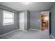 A gray bedroom showcases a kitchen entrance, complementing its two light-filled windows at 3449 Hyland Dr, Decatur, GA 30032