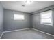 Bright bedroom featuring two windows, soft carpet, and neutral gray walls at 3449 Hyland Dr, Decatur, GA 30032