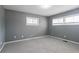 Bright bedroom featuring two windows, soft carpet, and neutral gray walls at 3449 Hyland Dr, Decatur, GA 30032