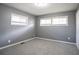 Bright bedroom featuring gray walls, two windows letting in natural light, and neutral carpet flooring at 3449 Hyland Dr, Decatur, GA 30032