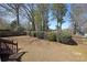 Large backyard with a sloped lawn, a wooden fence, and mature trees providing privacy at 4584 Madison Place Ln, Atlanta, GA 30360