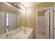 Bright bathroom with double sinks, a large mirror, and a door to a separate shower/tub area at 4584 Madison Place Ln, Atlanta, GA 30360