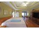 Spacious bedroom with a tray ceiling, hardwood floors, and a sitting area bathed in natural light at 4584 Madison Place Ln, Atlanta, GA 30360