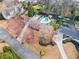 Aerial view of a house with a pool, a long driveway, and mature trees at 4755 Huntley Dr, Atlanta, GA 30342