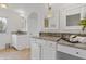 Bright bathroom featuring dual granite vanities, white cabinets, and neutral tile flooring at 4755 Huntley Dr, Atlanta, GA 30342