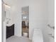 Bright bathroom featuring a dark vanity, round mirror and doorway leading to a bedroom at 4755 Huntley Dr, Atlanta, GA 30342