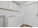 This laundry room features a full-size washer and dryer, overhead cabinets, and direct access to the backyard at 4755 Huntley Dr, Atlanta, GA 30342