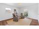 Living room featuring hardwood floors, a patterned rug, comfortable seating and two large windows at 4755 Huntley Dr, Atlanta, GA 30342