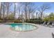 Backyard pool area with stone trim, chaise lounges, lush landscaping, and privacy fence at 4755 Huntley Dr, Atlanta, GA 30342