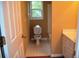 Functional bathroom with a standard toilet, white tiled floor, and natural light from the window at 100 Shoreline Dr, Fayetteville, GA 30215