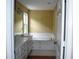 Bright bathroom with white tiled walls, white cabinets, and a large mirror for a fresh, clean space at 100 Shoreline Dr, Fayetteville, GA 30215