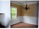 Cozy dining room featuring a classic chandelier, chair rail, and large window at 100 Shoreline Dr, Fayetteville, GA 30215