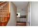 Inviting hallway with wooden stairs leads to a bright kitchen with white cabinets at 100 Shoreline Dr, Fayetteville, GA 30215