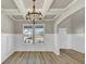 Traditional dining room with wainscotting, wood-look floors, trey ceiling, and modern chandelier at 1734 Cadence St, Locust Grove, GA 30248