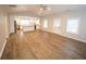 Open living room features a large window, modern ceiling fan, and views of the updated kitchen at 2084 North Rd, Snellville, GA 30078