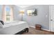 This bedroom features light-gray walls, a neutral carpet, TV, bedside lamp, and a window view at 4704 Keighley Dr, Stone Mountain, GA 30083