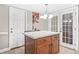 A charming kitchen island featuring a white countertop with cherry wood cabinetry and conveniently placed doors to the yard at 4704 Keighley Dr, Stone Mountain, GA 30083