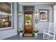 Inviting front porch with a craftsman-style front door, decorative sconces, and potted plants at 513 Saint Charles Ne Ave, Atlanta, GA 30308