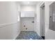 Cozy laundry room with tiled floor, white cabinets, and beadboard, offering a functional space at 513 Saint Charles Ne Ave, Atlanta, GA 30308