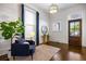 Bright living room with hardwood floors, large windows, blue curtains, and comfortable seating by the entryway at 513 Saint Charles Ne Ave, Atlanta, GA 30308