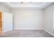 A bright bedroom showcases tray ceilings, neutral walls, and doorway leading to a bathroom at 223 Villa Park Cir, Stone Mountain, GA 30087