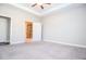 A sunlit bedroom with a tray ceiling, plush carpet, and door to the luxurious bathroom at 223 Villa Park Cir, Stone Mountain, GA 30087