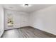 Clean bedroom featuring wood-look floors, a window for natural light, and a double door closet at 2412 Renny Ct, Marietta, GA 30066