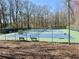 Well-maintained tennis courts with benches, surrounded by a fence and trees at 3533 Mulberry Way, Duluth, GA 30096