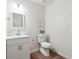 Updated half bath with white vanity, framed mirror, modern lighting, and wood-look vinyl flooring at 4282 Worth Nw St, Acworth, GA 30101