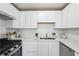 Modern kitchen showcasing pristine white cabinetry, complemented by a sleek stainless steel range at 4282 Worth Nw St, Acworth, GA 30101