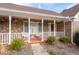 Inviting front porch with stone accents, white railings, and charming décor at 1165 Saint Ives Ct, Suwanee, GA 30024