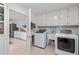 Convenient laundry room with washer, dryer, utility sink, and white cabinets for storage at 1165 Saint Ives Ct, Suwanee, GA 30024