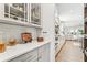 Kitchen wet bar featuring custom cabinets, display shelving, and hardwood floors at 2764 Bateman Sw St, Powder Springs, GA 30127
