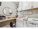 Bright laundry room with white cabinets, butcher block countertop, and modern washer and dryer at 2764 Bateman Sw St, Powder Springs, GA 30127