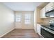 Bright kitchen has white cabinets, granite countertops, stainless steel appliances, and a door to the backyard at 433 Kara Ln, Mcdonough, GA 30253