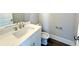 Powder room featuring a marble countertop, white cabinet, faucet, sink and toilet at 827 Winslow Nw Way, Atlanta, GA 30318