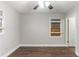 A neutral bedroom features a ceiling fan, wood-look floors, and a window boarded up at 3761 Turner Heights Dr, Decatur, GA 30032