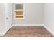 Bedroom showcasing wood-look flooring, neutral paint, and a boarded-up window at 3761 Turner Heights Dr, Decatur, GA 30032