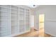 Bedroom with large built in shelving, ceiling fan, hardwood floors and view of the bathroom at 4875 Gladstone Pkwy, Suwanee, GA 30024