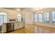 Bright dining room with hardwood floors with white shuttered windows and stainless appliances in kitchen at 4875 Gladstone Pkwy, Suwanee, GA 30024