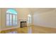 Cozy living room with hardwood floors, fireplace, and ample natural light from arched windows at 4875 Gladstone Pkwy, Suwanee, GA 30024