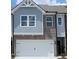 Charming townhome with a white garage door, brick and shingle siding, and coordinated window trim at 541 Tuskegee St # 49, Mcdonough, GA 30253