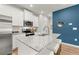 Modern kitchen featuring white cabinets, granite countertops, stainless steel appliances, and a vibrant blue accent wall at 541 Tuskegee St # 49, Mcdonough, GA 30253